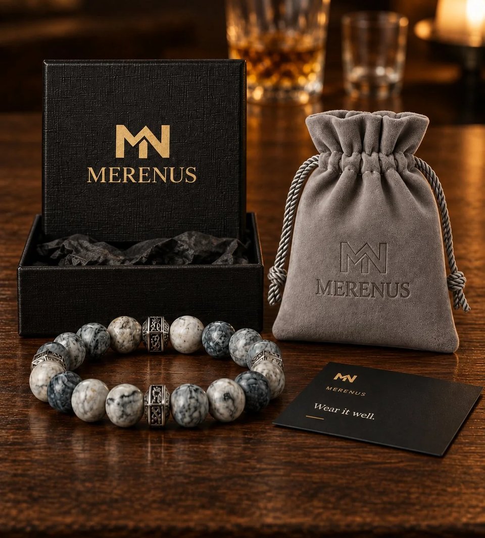 A Merenus bracelet shown with its gift packaging: a black logo gift box, a gray velvet drawstring pouch, and a card reading Wear it well